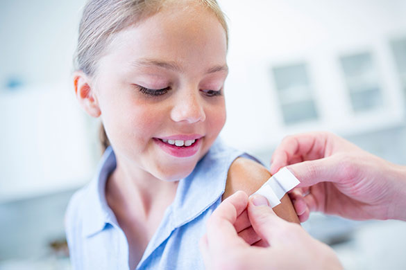 nurse-putting-bandaid-on-girls-arm-after-getting-immunization.jpeg